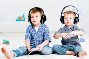 Coppia di bambini che gioca con i videogames, una possibile causa del mal di testa